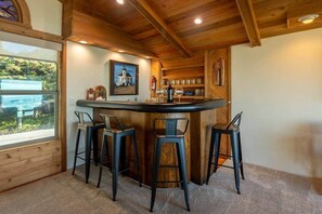 A bar area with wooden ceiling, a window with a view, and a painting on the wall. - Solitude in Seal Rock (Seal Rock)
