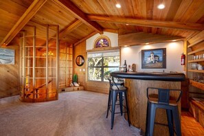 A wooden interior with a bar area, seating, and a large window. - Solitude in Seal Rock (Seal Rock)