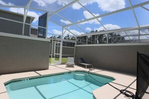Una piscina interna con tetto in vetro, due poltrona relax e vista libera sul cielo.