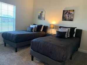 A bedroom with two beds, a nightstand, a lamp, and Star Wars themed wall art. - Luxury 5 Bdrm Championsgate Pool, Water Park, Bbq (Davenport)