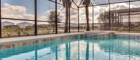 Una piscina con vistas claras del paisaje circundante, incluyendo palmeras y edificios al fondo.