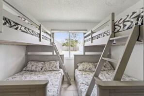 A dormitory room with bunk beds, a window, and a view of the outdoors. - Luxury Coastal Haven, Pool, Beach, Golf and Relax (Palm Coast)