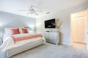 A bedroom with a bed, a ceiling fan, a TV, a dresser, and a closet. - Amazing 3 Bedroom with resort amenities (Davenport)