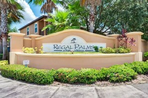 A sign for Regal Palms at High!s Reserve with a landscaped entrance and palm trees. - Amazing 3 Bedroom with resort amenities (Davenport)