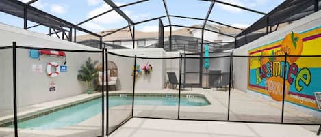An indoor swimming pool with a glass enclosure, surrounded by walls with safety signs and a mural.