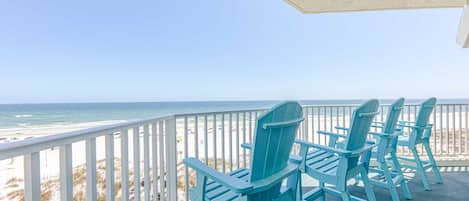 A balcony with a view of the beach and ocean.