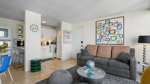 A modern living room with a grey sofa, a round coffee table, and a colorful abstract painting on the wall. - Whimsical mid-century mod at famed Ocotillo Lodge (Palm Springs)