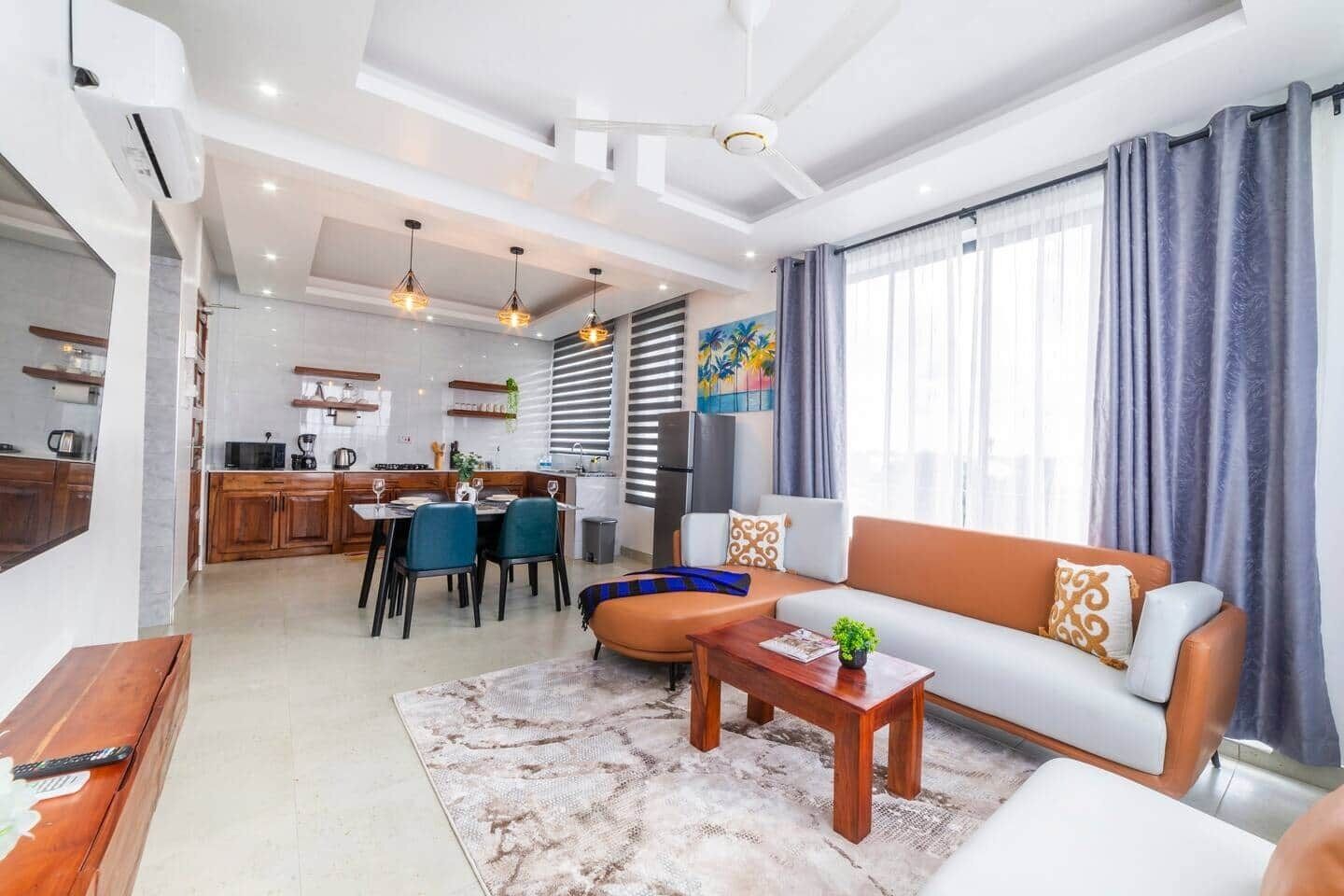 A modern living room with a sofa, coffee table, and dining area.