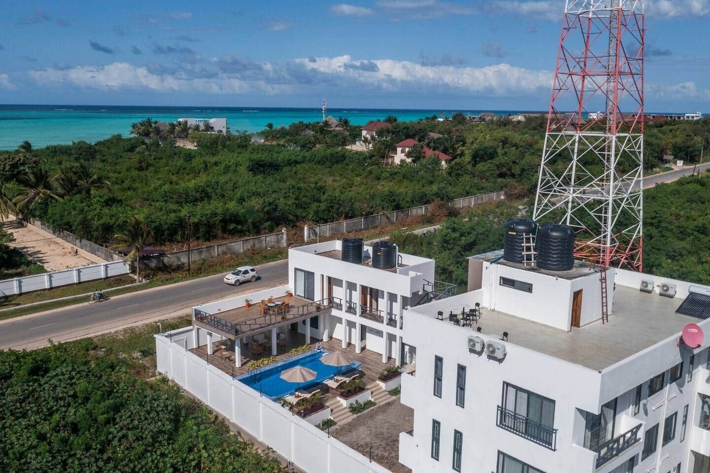 A modern building with a rooftop pool and a view of the ocean.