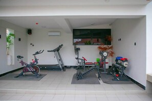 Ein Fitnessstudio mit Ergometer, Laufbändern und Gewichten.