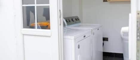 Une buanderie équipée d’un lave-linge, d’un sèche-linge et d’un meuble de rangement.
