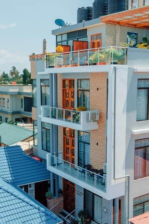 A multi-story building with balconies, large windows, and a flat roof. - The Lavish suite with Sunset view @Arikays homes (Dar es Salaam)