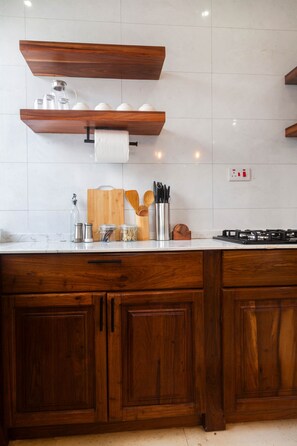 Eine Küche mit Holzschränken, einer Arbeitsplatte, einem Gasherd und verschiedenen Küchenutensilien.