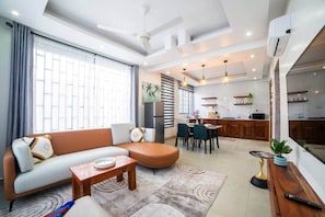 A modern living room with a sofa, coffee table, and dining area. - Seashells Private Apt - Kitchen| Pool |Wi-Fi | Beachwalk (Jambiani Kikadini)