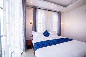 A hotel room with a bed, curtains, and wall sconces. - Seashells Private Apt - Kitchen| Pool |Wi-Fi | Beachwalk (Jambiani Kikadini)