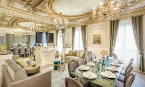 Ein luxuriöser Speisesaal mit einer Kristallleuchter, einem Fernseher und einem Kamin.