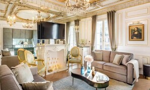 Ein luxuriöses Wohnzimmer mit Kamin, stilvollem Mobiliar und einem Gemälde der Mona Lisa.