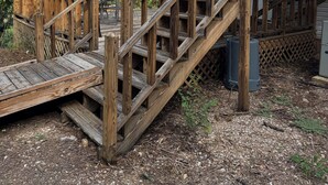 Una escalera de madera que lleva a una casa con terraza.
