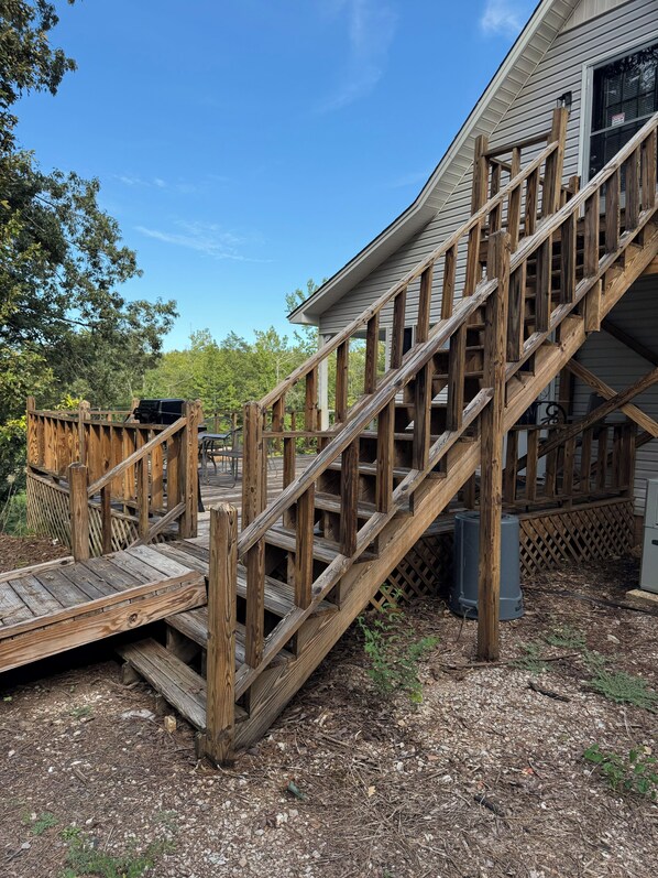 Una escalera de madera que lleva a una casa con terraza.