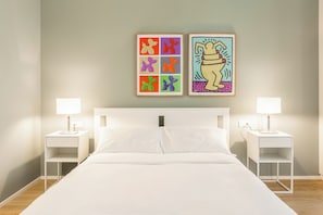 A hotel room with a bed, two bedside tables, two lamps, and two framed artworks on the wall. - Pirandello 3 - Studio Apartment, Sleeps 4 (Milano)