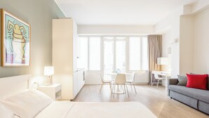 A hotel room with a bed, a desk, a dining table, and a sofa. - Pirandello 3 - Studio Apartment, Sleeps 4 (Milano)