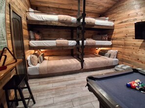 A bunk bed room with a pool table and a television. - IIII Pines + a Cone: Sleeps 18, Hot Tub, Game Room (Hochatown)