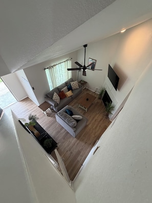 Ein modernes Wohnzimmer mit einer Couch, einem Couchtisch und einem Deckenventilator.