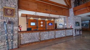 A reception area with a wooden reception desk, stone walls, and a clock. - Erta Soyak Hotel Sarıkamış (Sarıkamış)