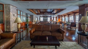 A spacious lobby with a stone wall, leather sofas, a coffee table, and a chandelier. - Erta Soyak Hotel Sarıkamış (Sarıkamış)