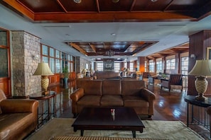 Eine geräumige Lobby mit Steinwand, Ledersofas, einem Couchtisch und einer Kristallleuchtre.