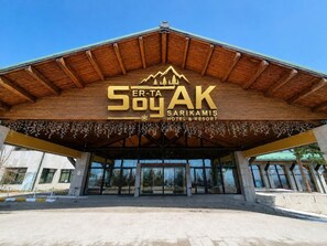 De ingang van het Ser-Ta Soak Hotel & Resort met een houten gevel en een berglogo.