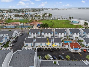 A hotel with multiple buildings, a parking lot, and a view of the ocean. - 2-bedroom Cozy Beach Getaway w/ Screened Lanai (Madeira Beach)