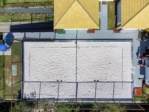 An aerial view of a large, open plaza with a sandy surface, surrounded by buildings and a fence. - Beautiful apartment in Praia do Forte, near the best beach. (Mata de São João)