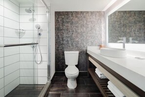 Un baño moderno con ducha, inodoro y tocador.