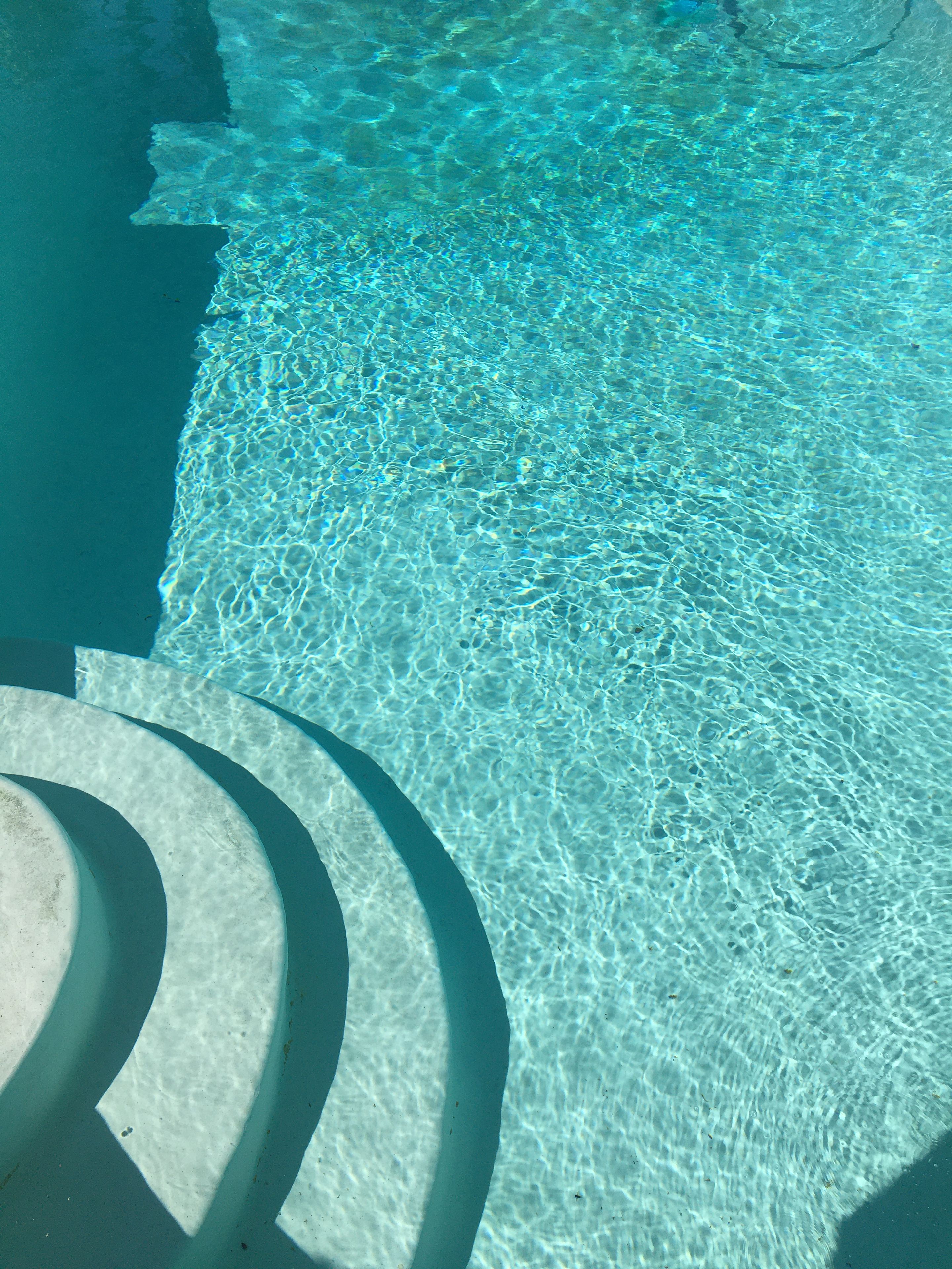 A clear pool with visible ripples and a circular structure in the foreground.