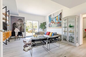 Ein modernes Wohnzimmer mit einer Couch, einer Vitrine und einem Gemälde.