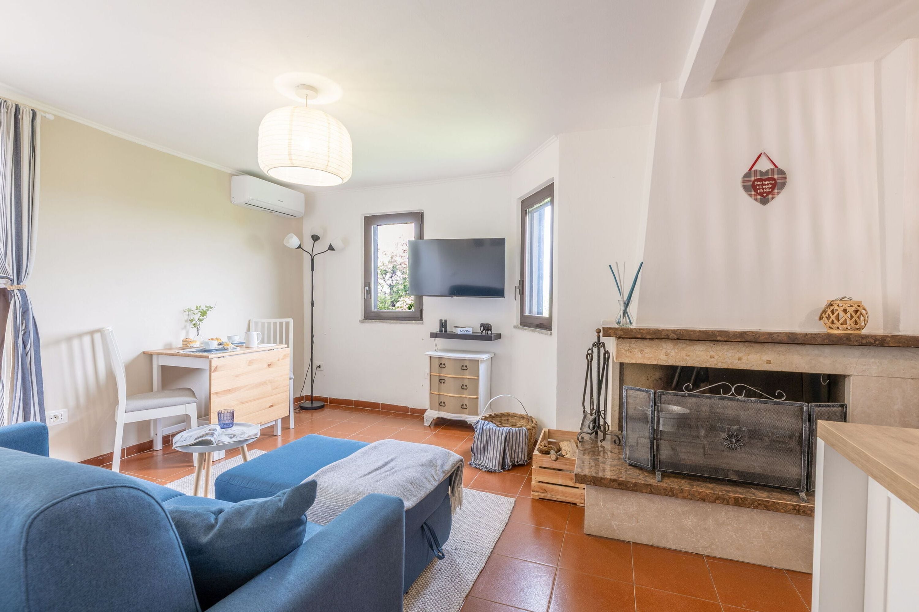 Ein modernes Wohnzimmer mit einer Couch, einem Fernseher, einem Kamin und einem Essbereich.