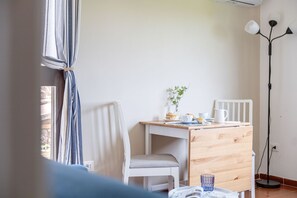 A room with a desk, chair, and a floor lamp. - La Terrazza nel Borgo (Marsciano)