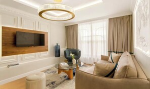 A modern living room with a flat-screen TV mounted on the wall, a round chandelier, a sofa, a coffee table, and a large window with curtains. - A REFINED CONTEMPORARY DESIGN WITH THE TIMELESS CHARM OF PARIS - MARAIS (Paris)