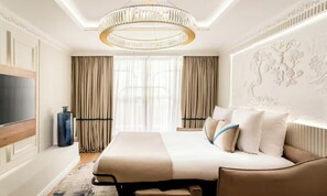 A modern hotel room with a large bed, a television, and a decorative wall panel. - A REFINED CONTEMPORARY DESIGN WITH THE TIMELESS CHARM OF PARIS - MARAIS (Paris)