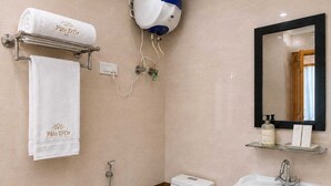 Een moderne badkamer met toilet, bidet, wastafel en handdoekhouder.