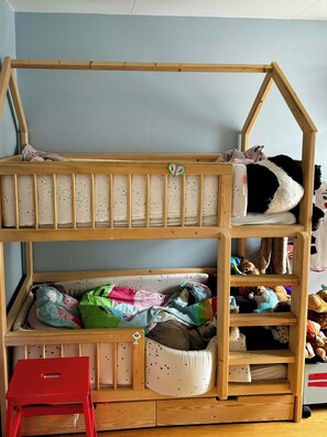 A bunk bed with a house-shaped headboard, a small red stool, and various stuffed toys. - House near Havnevigen with terrace and courtyard (København)