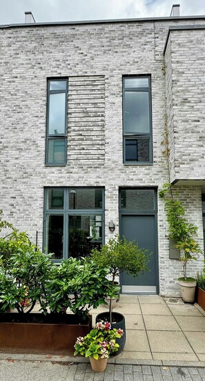 Un bâtiment moderne avec une façade en briques, de grandes fenêtres et un toit plat.