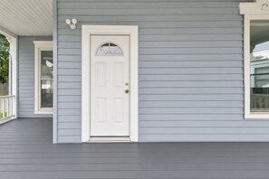 A house with a white front door, a covered porch, and a window. - Clubhouse - All Star Baseball Rentals (Oneonta)