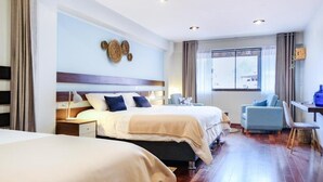 Una habitación de hotel con dos camas, un escritorio y una silla.