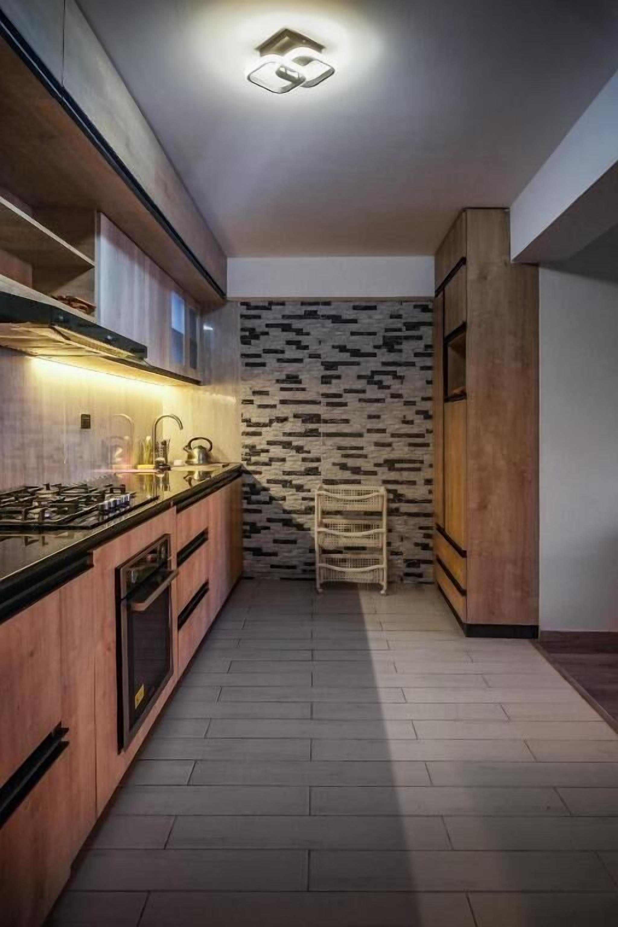 A modern kitchen with a central island, built-in appliances, and a patterned backsplash.