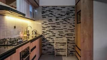 A modern kitchen with a central island, built-in appliances, and a patterned backsplash.