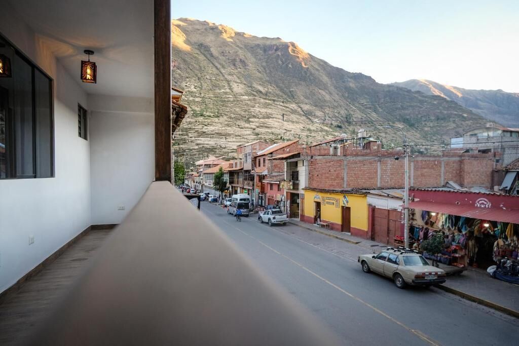 A street view with buildings, a mountain in the background, and a car parked on the side.