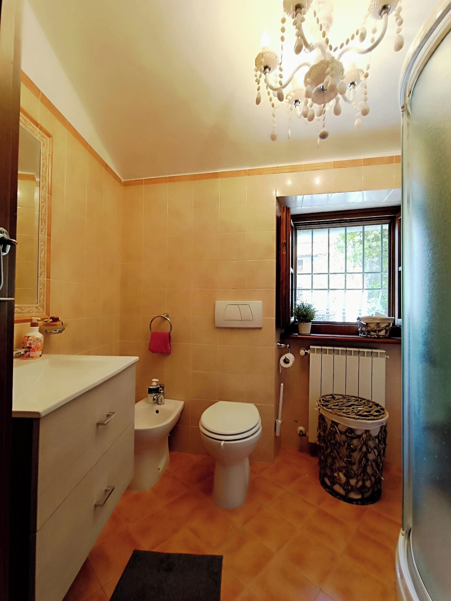 Ein Badezimmer mit Toilette, Bidet, Waschtisch und einem Fenster mit Blick.