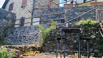 Ein Steingebäude mit Balkon, eine Metallkonstruktion im Vordergrund und ein klarer Himmel.